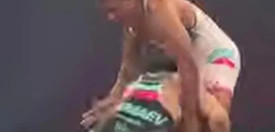 Two wrestlers engaged in a match on the mat