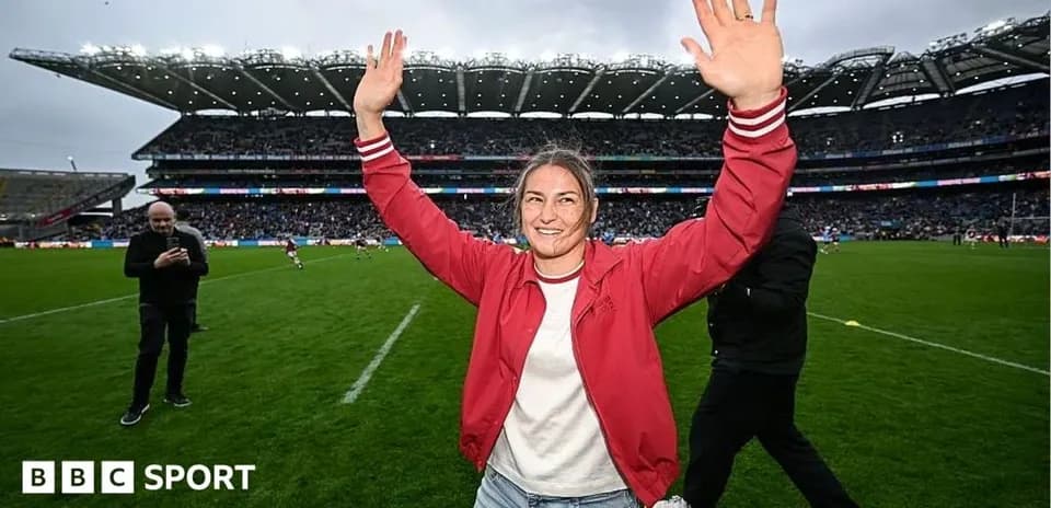 Woman celebrating with arms raised on rugby field