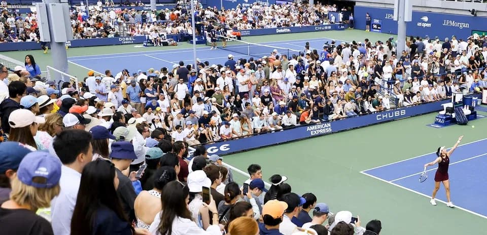 Tennis player serving to crowd at US Open match