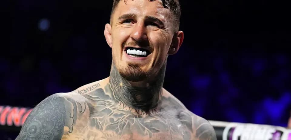 Fighter smiling with tattoos in boxing ring
