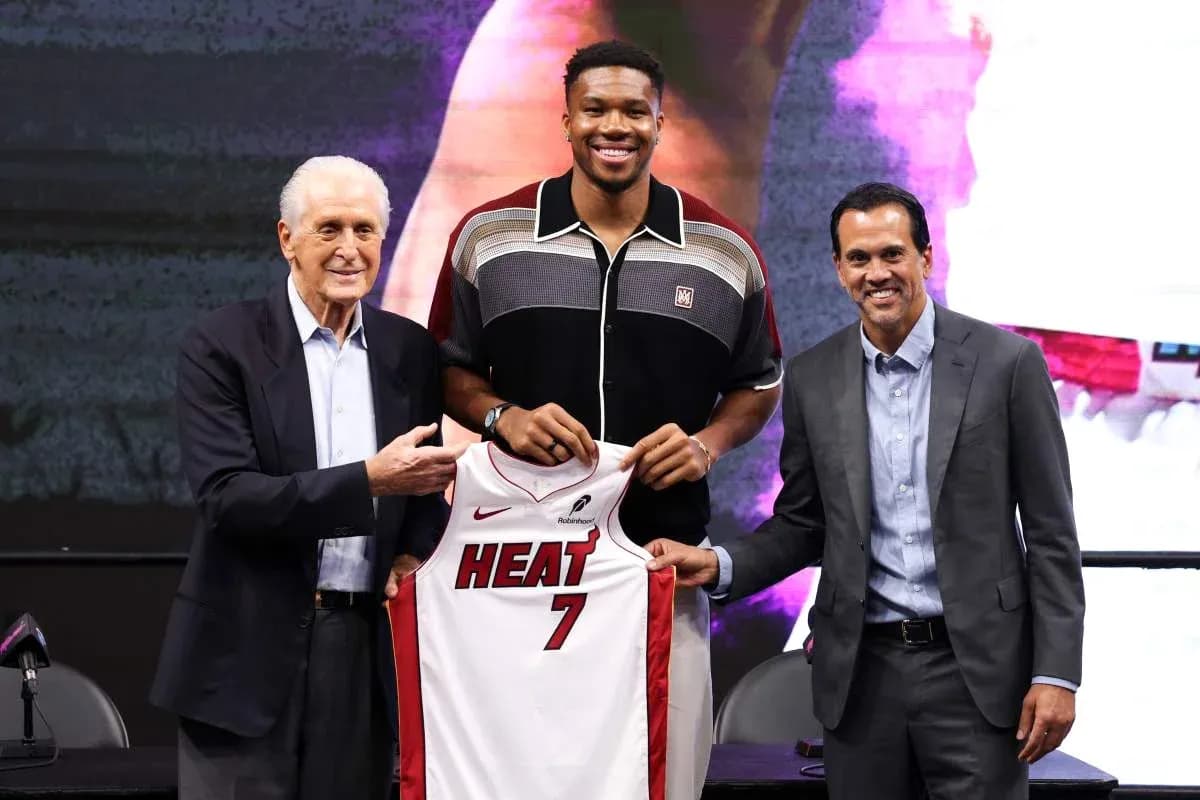 New player holding Miami Heat jersey at press conference