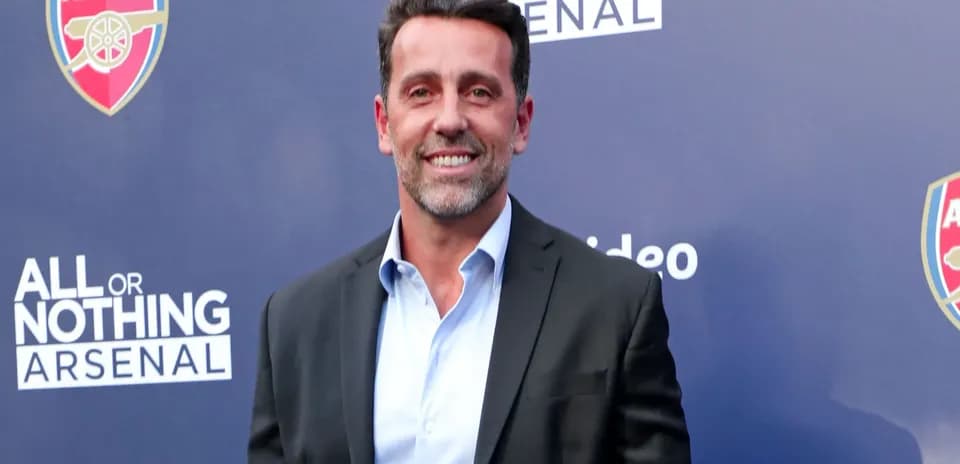 Person smiling at event with Arsenal branding