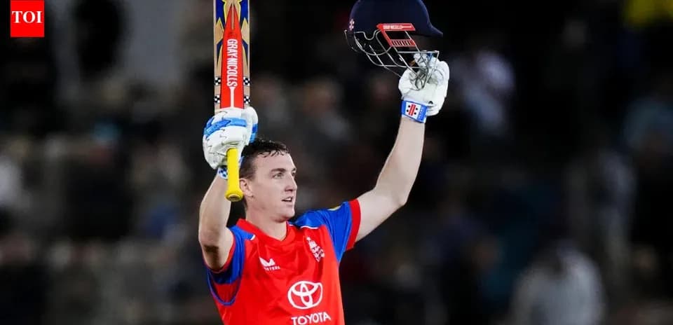 Batter celebrating century with raised bat and helmet