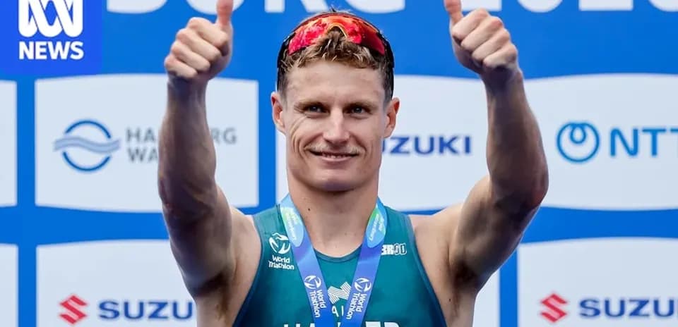 Athlete celebrating with thumbs up and medal
