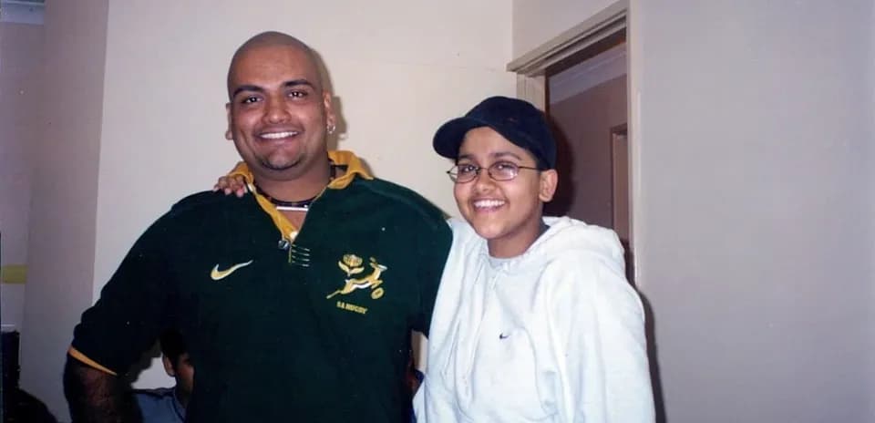 Two individuals posing together in casual clothing