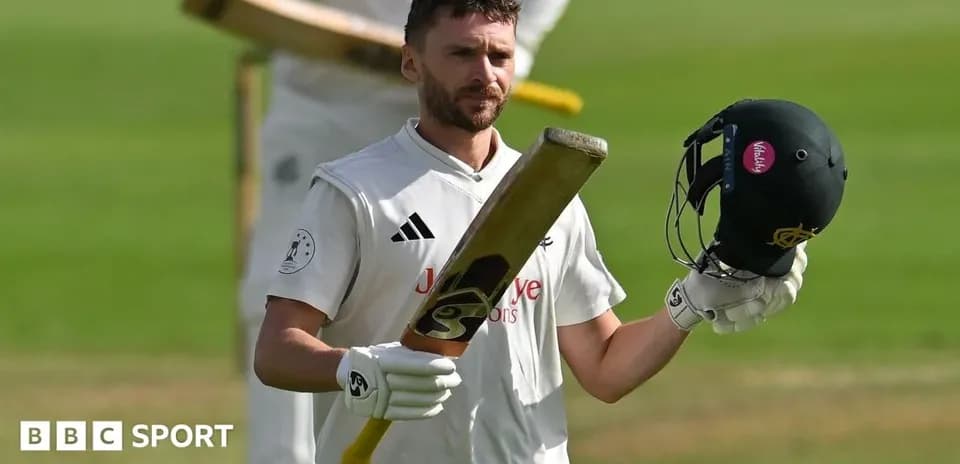 Batsman celebrating with helmet and bat raised