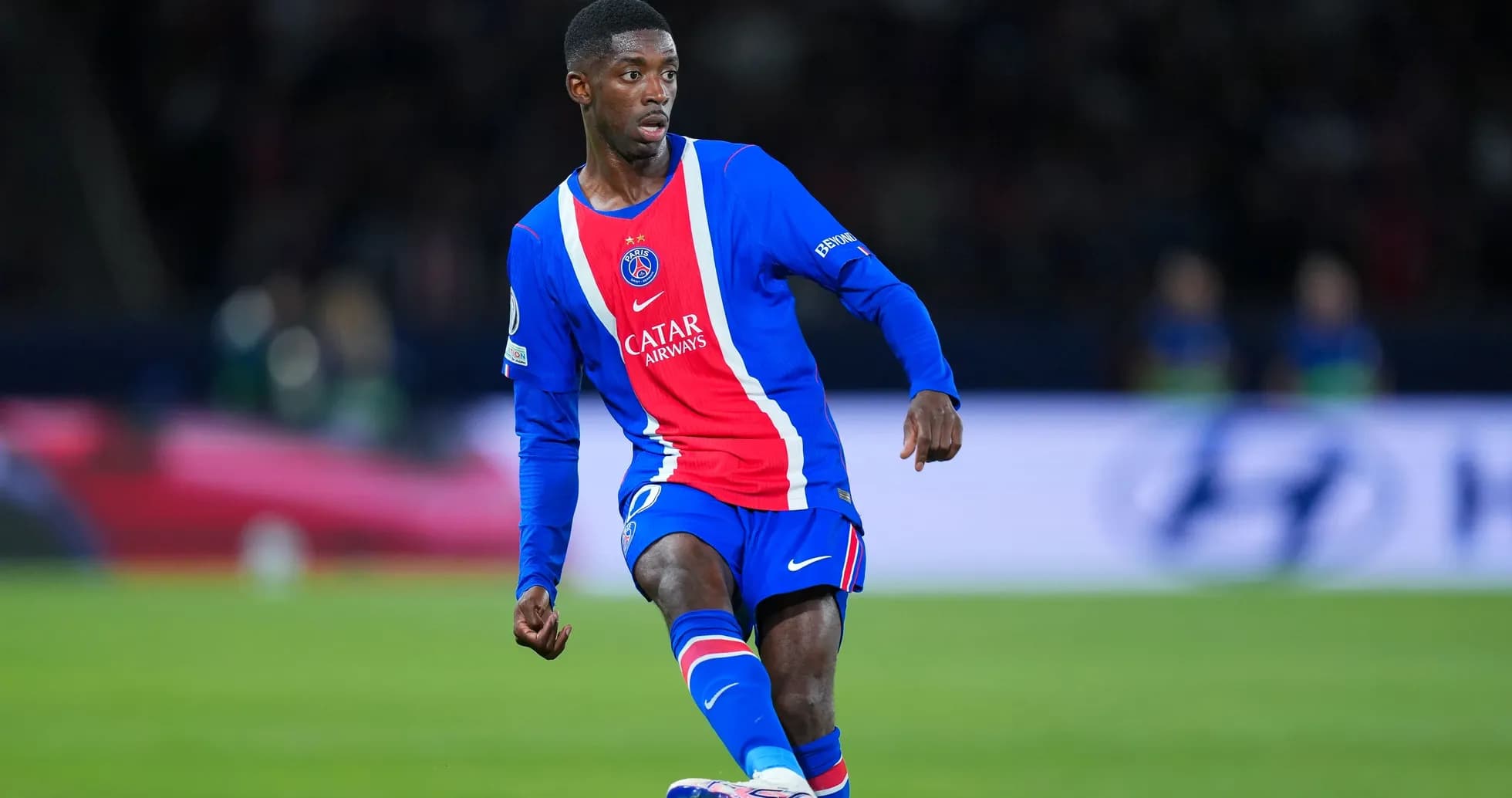 Player in PSG kit dribbling the ball during match