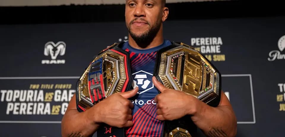 Fighter displaying championship belts at press event