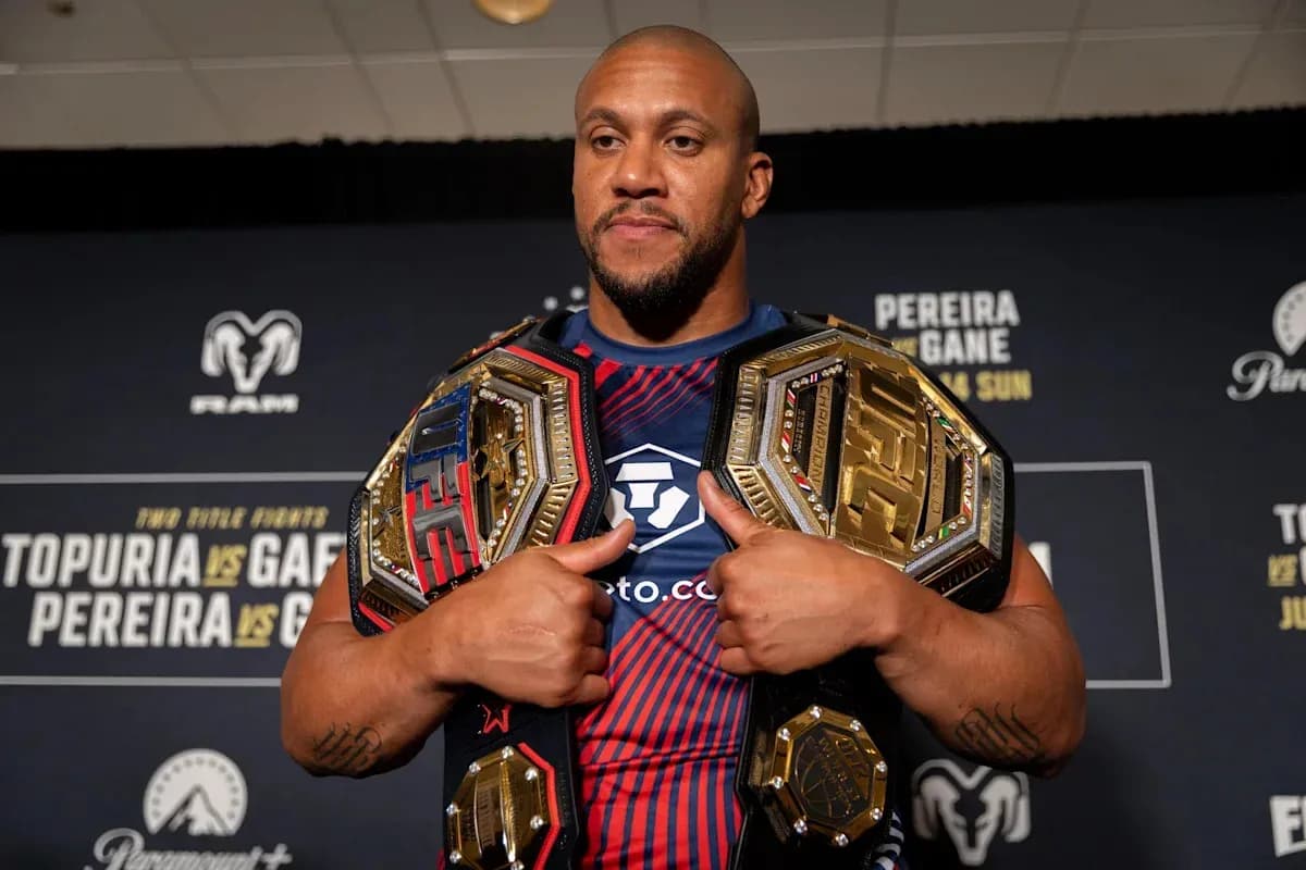 Fighter displaying championship belts at press event
