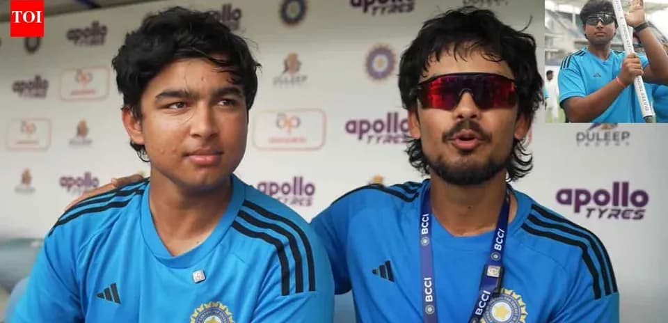 Two players in blue jerseys at press conference