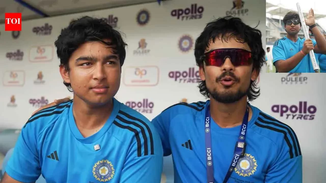 Two players in blue jerseys at press conference