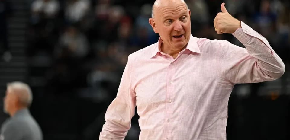 Man in pink shirt gesturing during basketball game