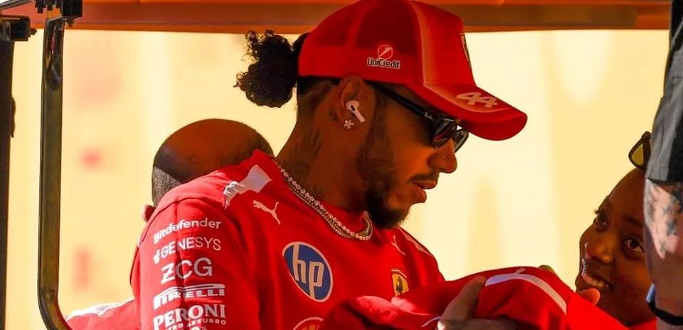 Driver in Ferrari attire interacting with a child