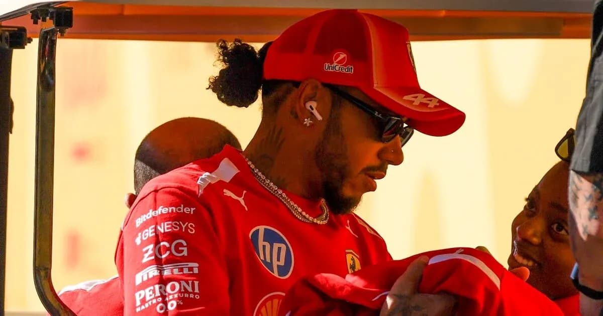 Driver in Ferrari attire interacting with a child