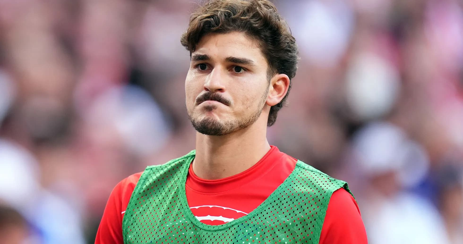Player in training bib during match warm-up