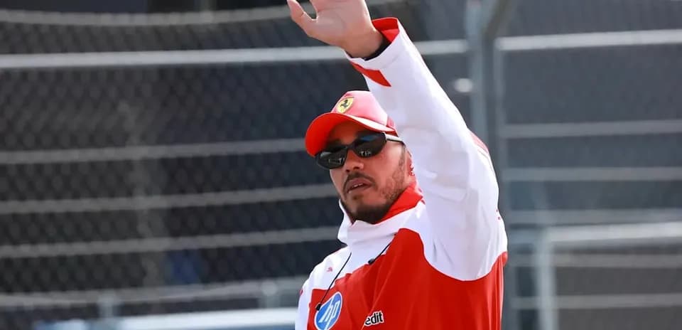 Driver waving while wearing racing team uniform