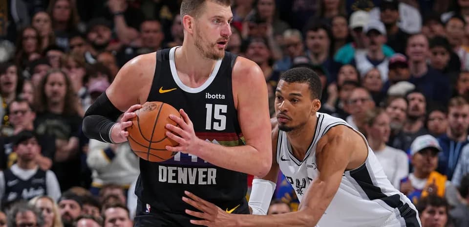 Nikola Jokić dribbling while defended by opponent