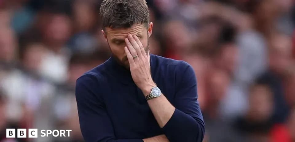 Coach with hand on forehead during match