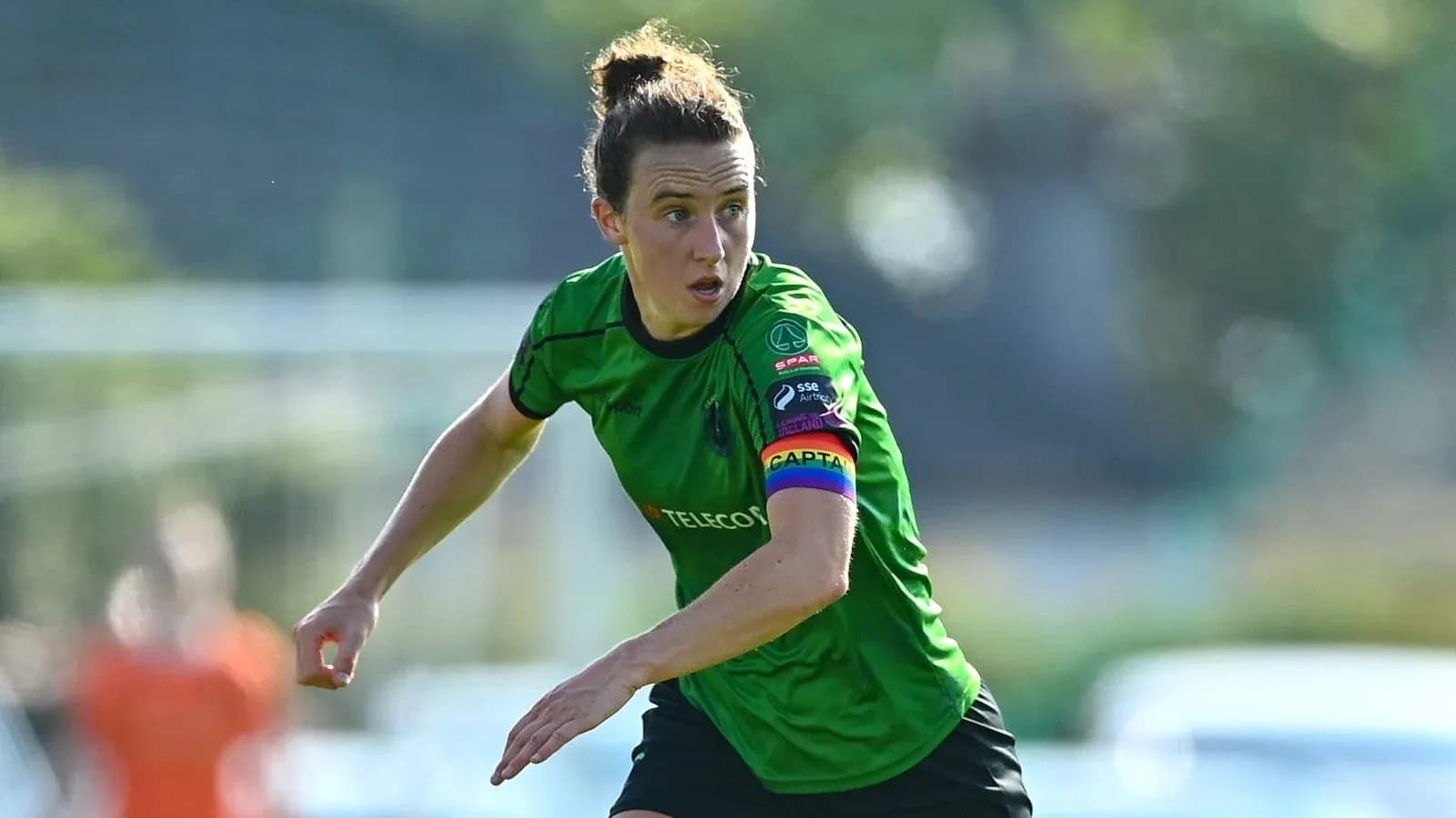 Player in green jersey running during a match