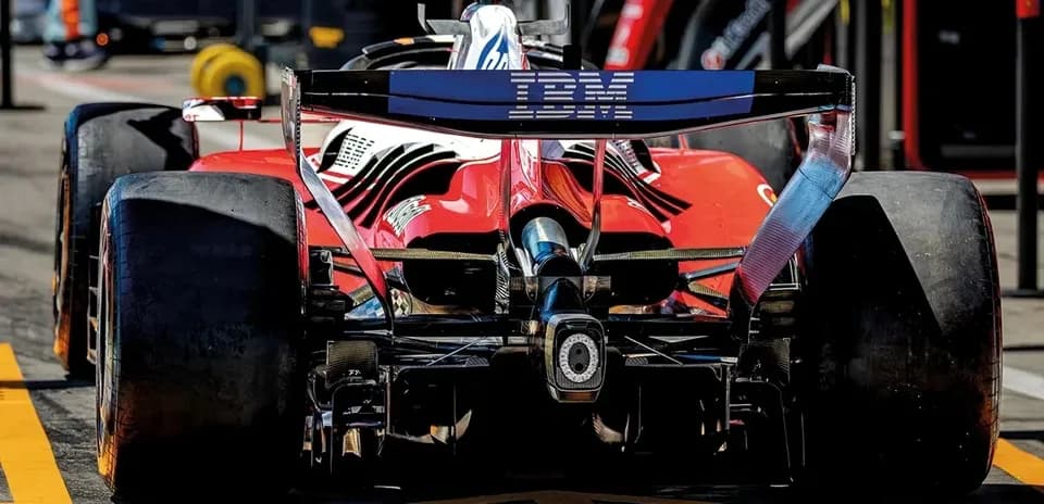Red race car with IBM branding in pit lane
