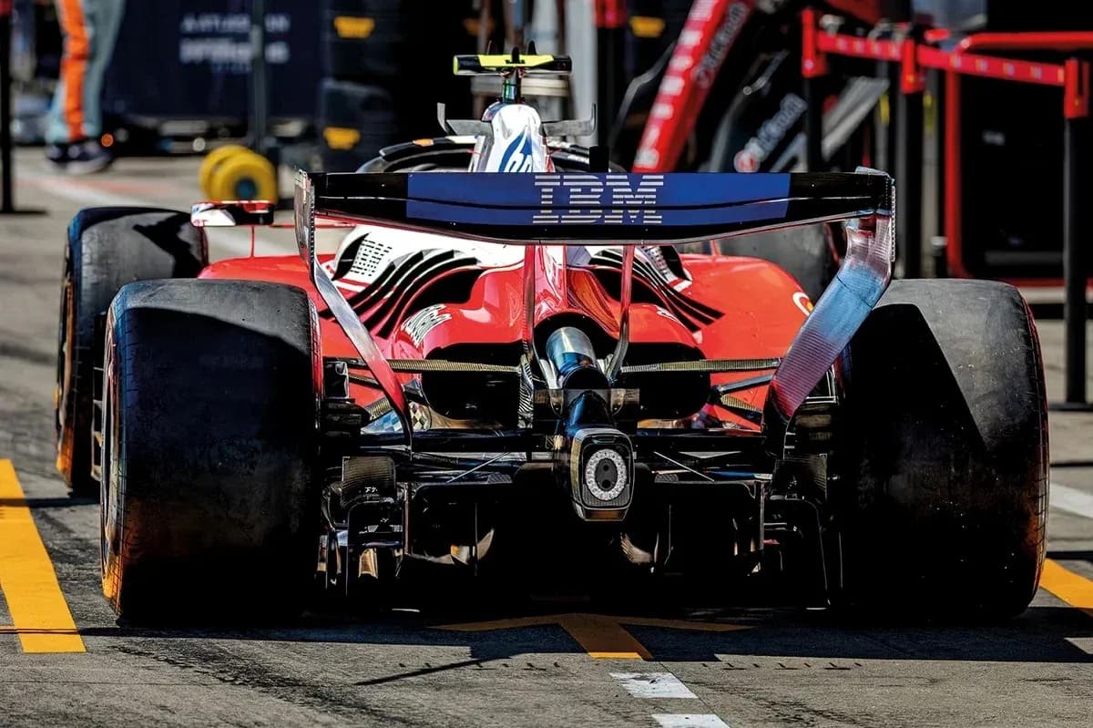 Red race car with IBM branding in pit lane