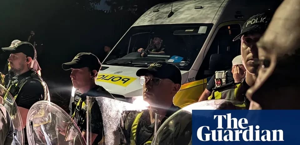 Police officers in riot gear at night