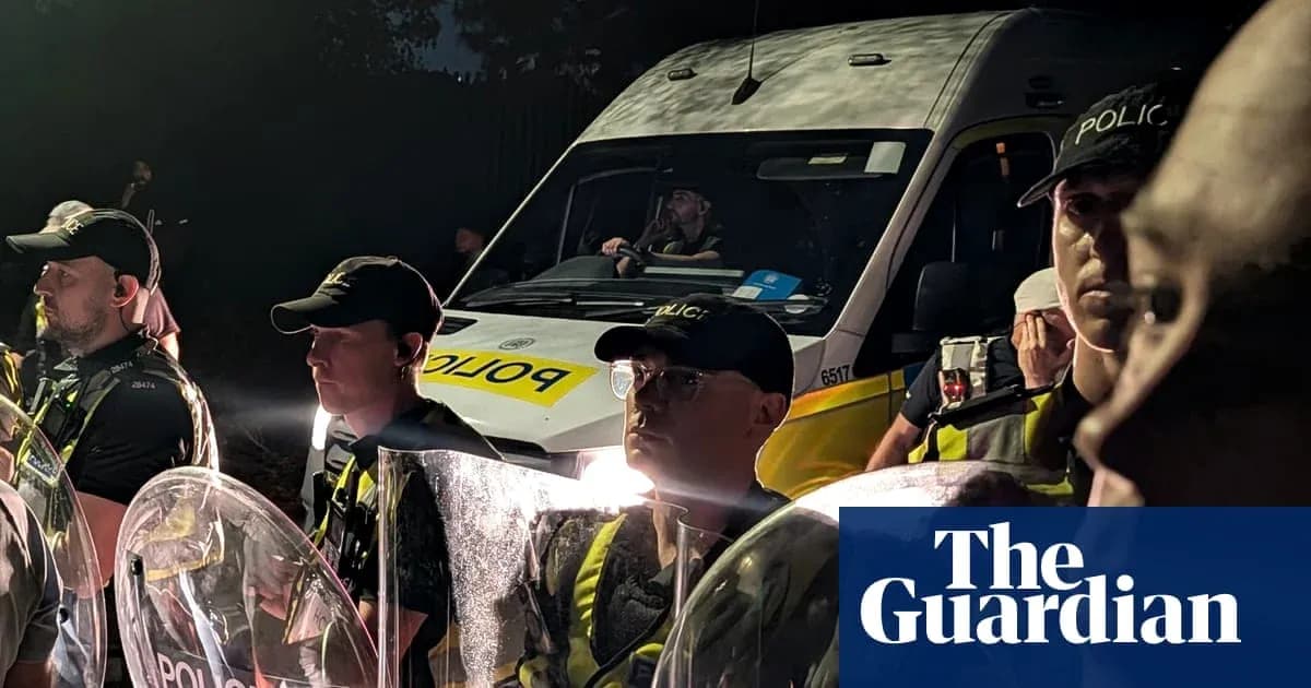 Police officers in riot gear at night