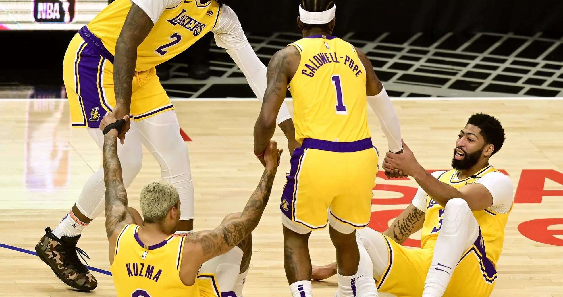 Lakers players helping teammates get up from floor