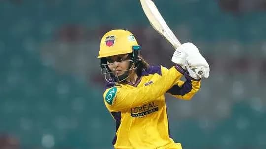 Batter in yellow jersey preparing to strike ball