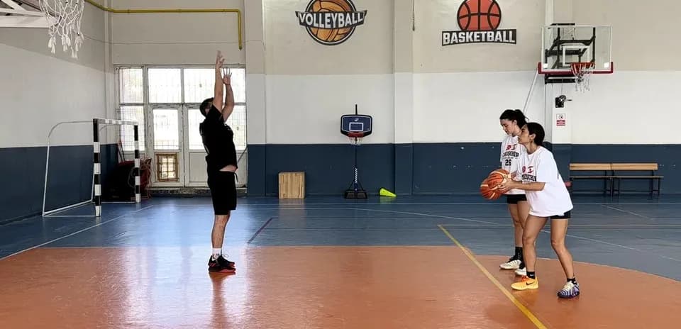 Coach demonstrating shooting technique to two players