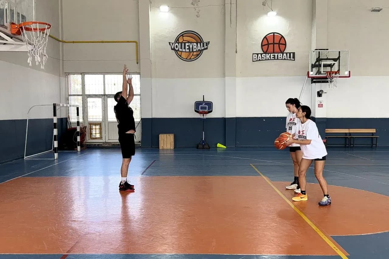Coach demonstrating shooting technique to two players Coach demonstrating shooting technique to two players