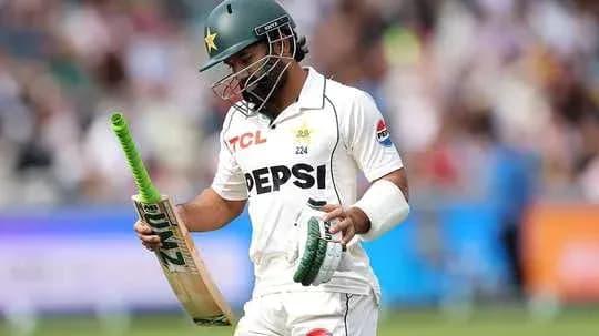 Batter walking off field holding cricket bat