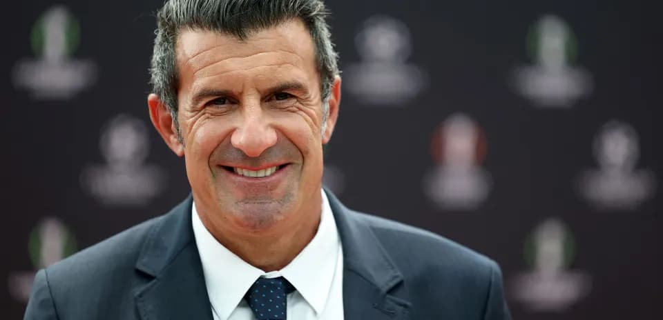 Man in a suit smiling at event backdrop