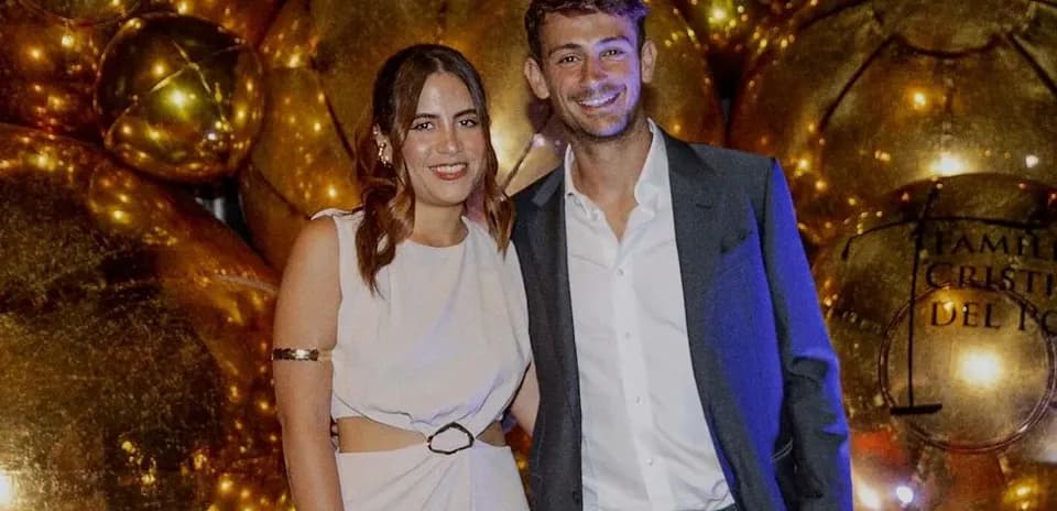 Couple posing in front of golden decorations
