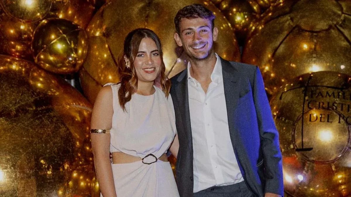 Couple posing in front of golden decorations