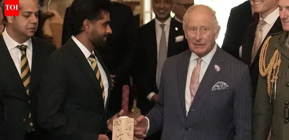 Cricketers presenting signed bat to King Charles