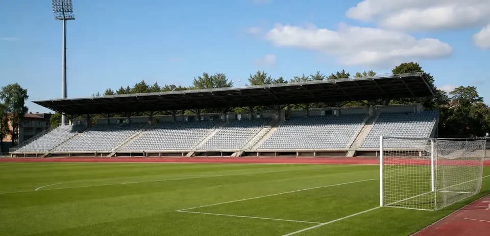 Empty stadium with green pitch and goalpost