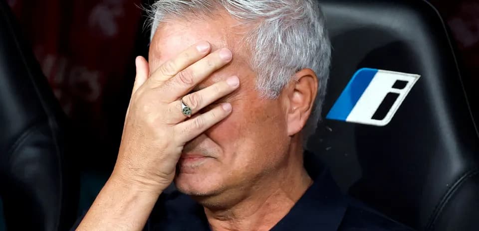 Manager covering face with hand on bench