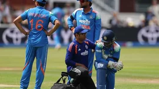 Indian cricket team members attending to injured player