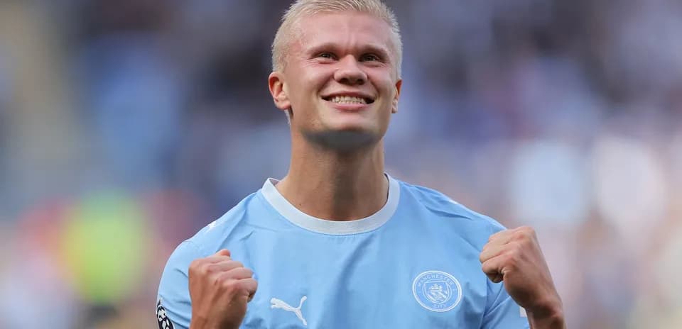 Player celebrating in Manchester City jersey on field