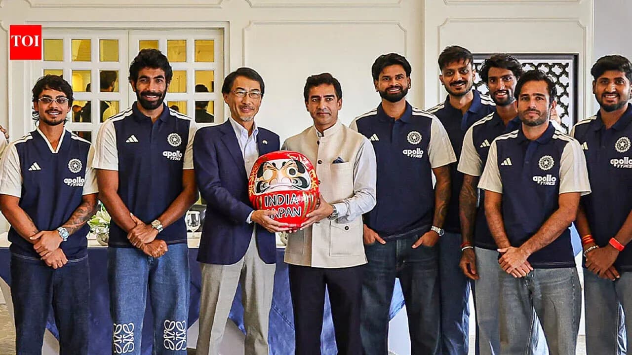 Cricket team posing with a Daruma doll