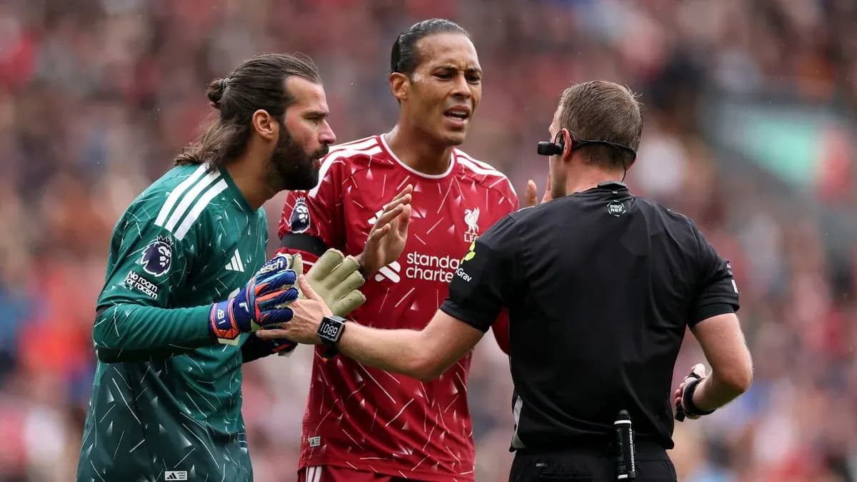 Goalkeeper and player discussing with referee during match