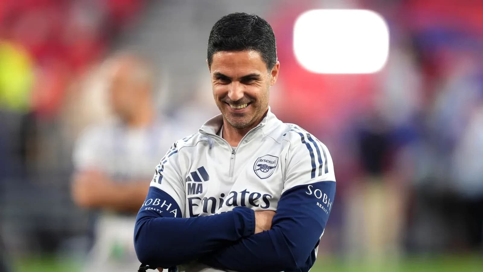Arsenal manager smiling with arms crossed