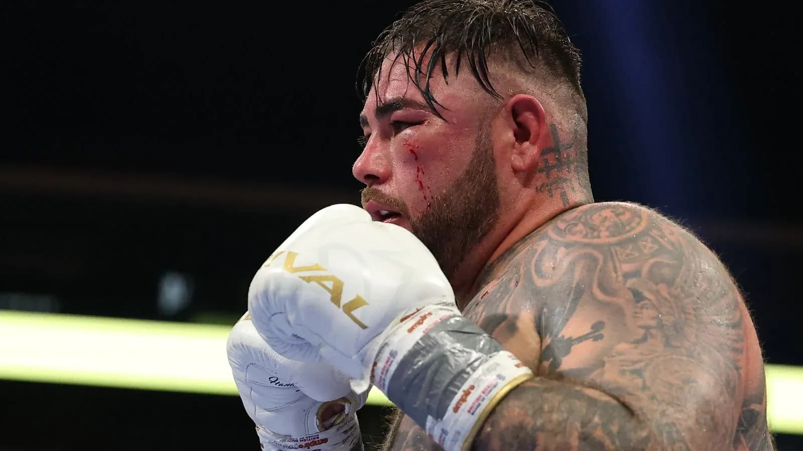 Boxer with blood on face preparing to fight