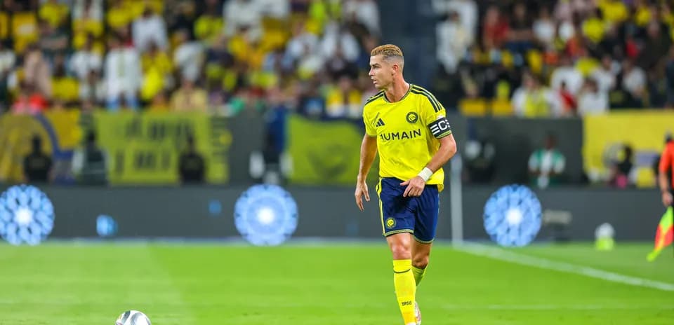 Player in yellow uniform running with soccer ball