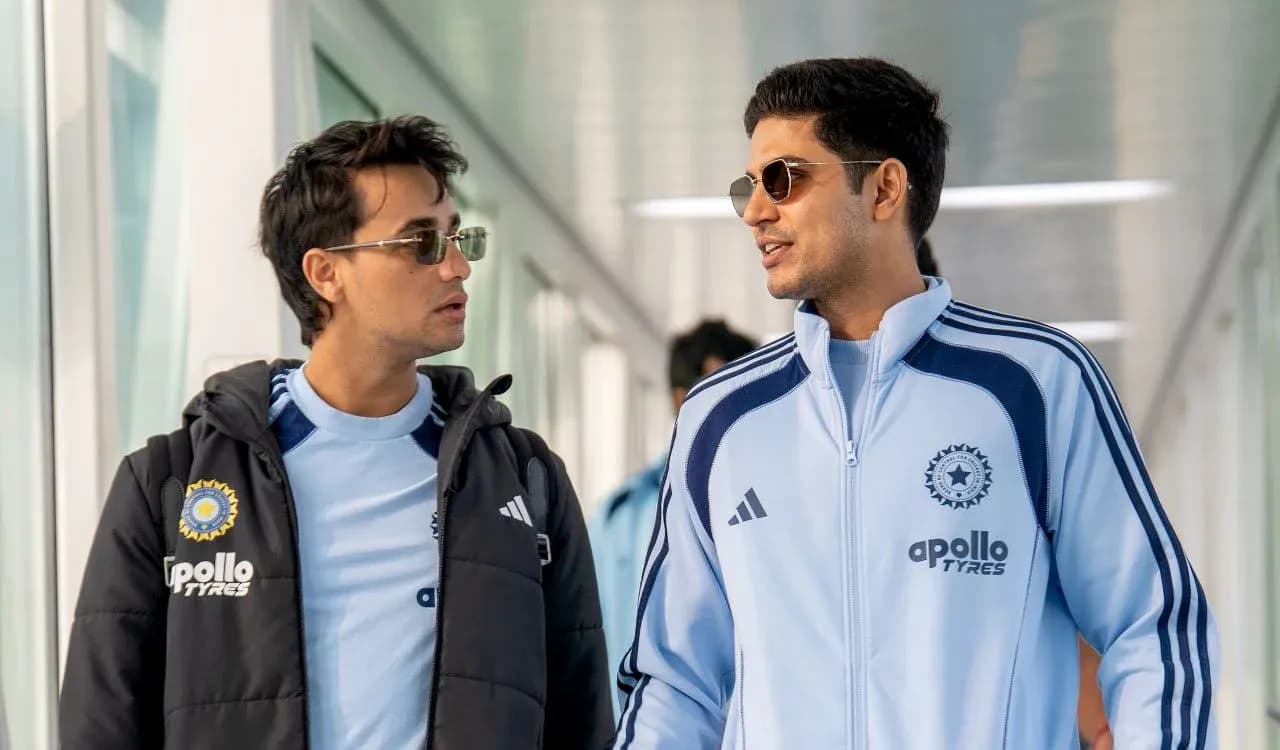 Two players walking in team tracksuits at venue