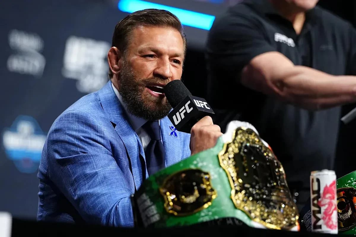 Fighter speaking into microphone with championship belt