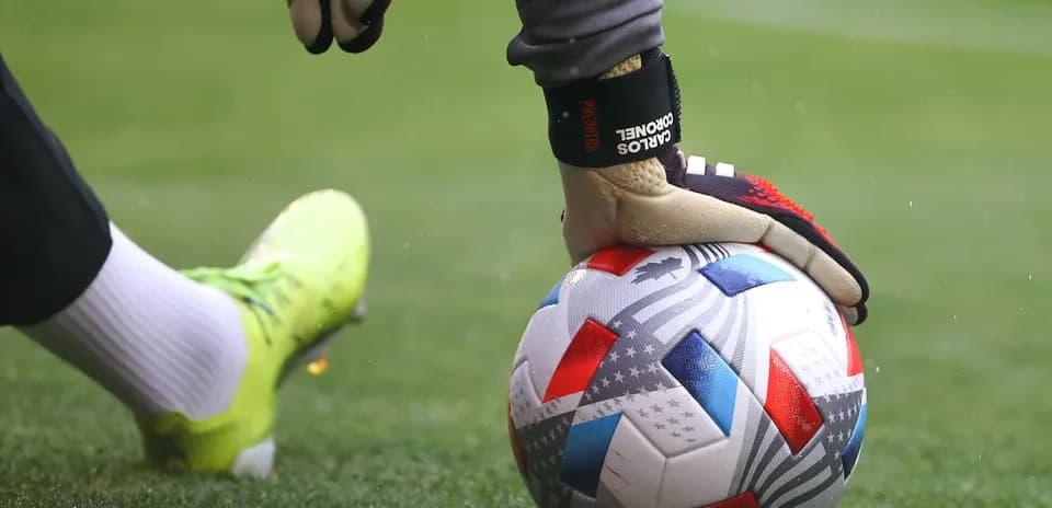 Goalkeeper placing ball on field during match
