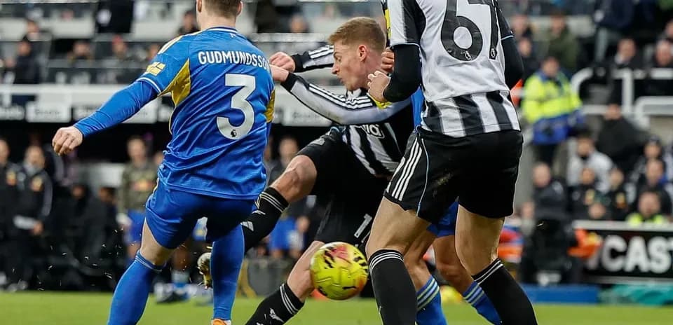 Leeds player challenges Newcastle opponent for the ball