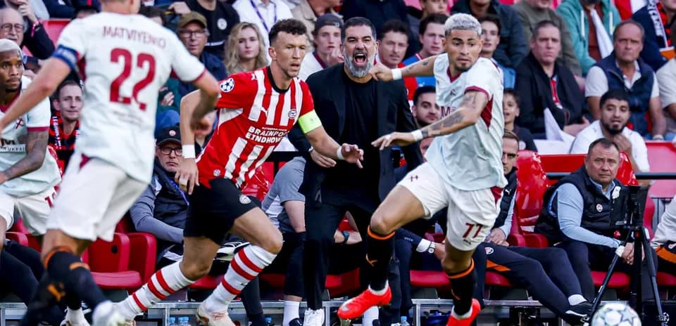 Players competing during a football match with coach reacting